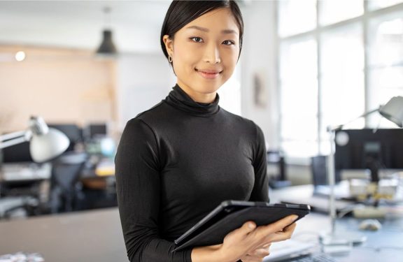 Woman smiling and holding a tablet