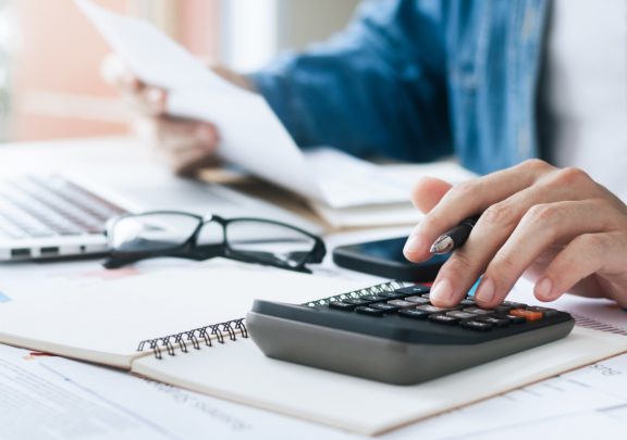 Hands typing on calculator