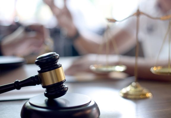 Judge's gavel and scales of justice on table