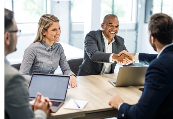 Business meeting with two men shaking hands across table