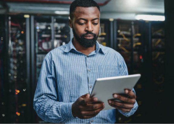 Man in data center looking at tablet